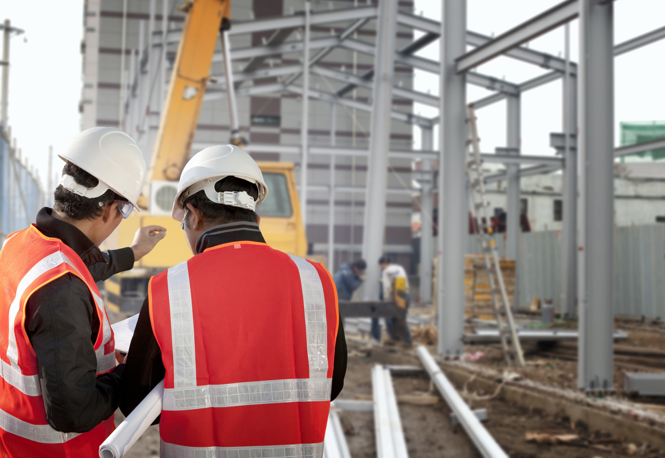 Two construction foremen reviewing plans on a jobsite, showing the overlap between foreman and supervisor roles